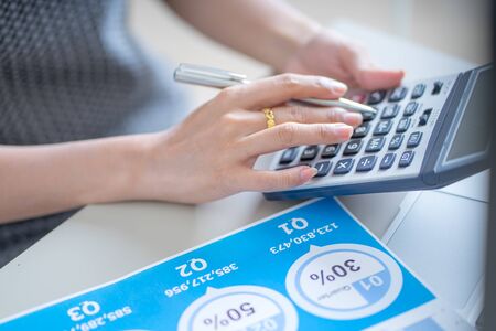 Asian business woman reviewing data in financial charts and graphs. Accountingの写真素材
