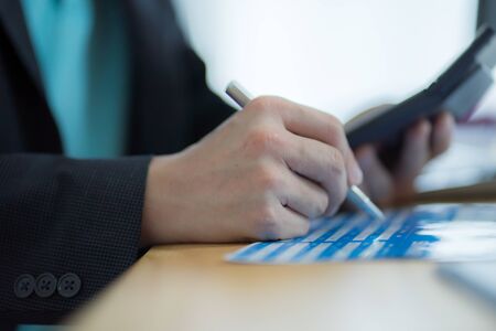 Businessman analyzing investment charts with laptopの写真素材