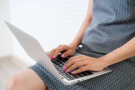 Portrait of young woman working and using laptop.の写真素材