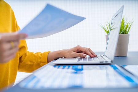 Business women reviewing data in financial charts and graphs. Accountingの写真素材
