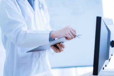 Close-up Of Male Doctor Filling The Medical Formの写真素材