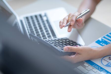 Asian business woman reviewing data in financial charts and graphs. Accountingの写真素材