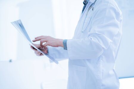 Close-up Of Male Doctor Filling The Medical Formの写真素材