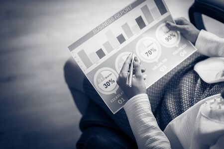 Asian business woman reviewing data in financial charts and graphs. Accountingの写真素材