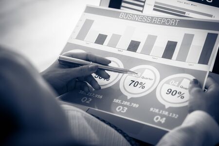 Asian business woman reviewing data in financial charts and graphs. Accountingの写真素材
