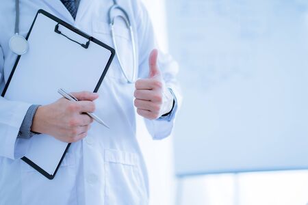 Close-up Of Male Doctor Filling The Medical Formの写真素材