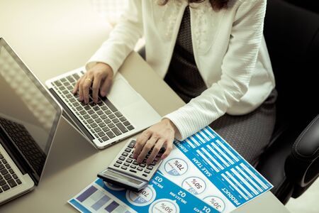 Asian business woman reviewing data in financial charts and graphs. Accountingの写真素材