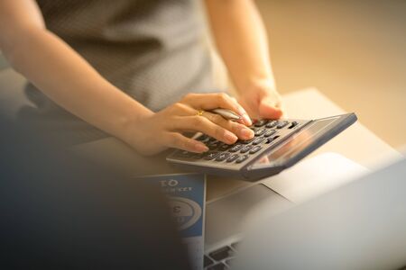 Asian business woman reviewing data in financial charts and graphs. Accountingの写真素材