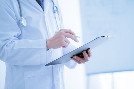 Close-up Of Male Doctor Filling The Medical Formの写真素材