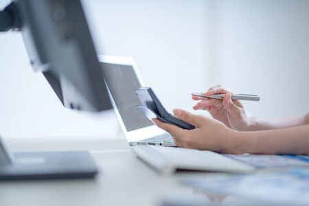 Asian business woman reviewing data in financial charts and graphs. Accountingの写真素材