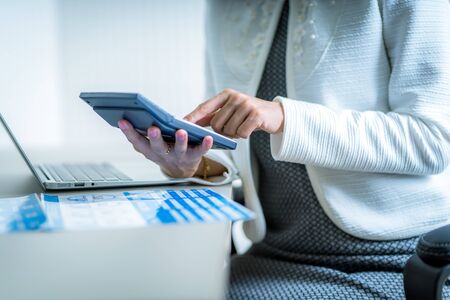 Asian business woman reviewing data in financial charts and graphs. Accountingの写真素材