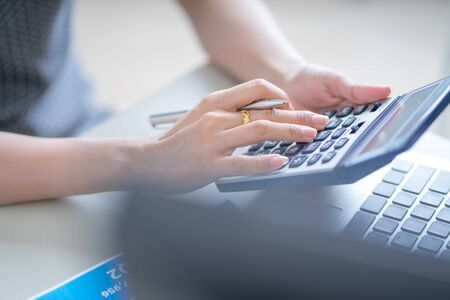 Asian business woman reviewing data in financial charts and graphs. Accountingの写真素材