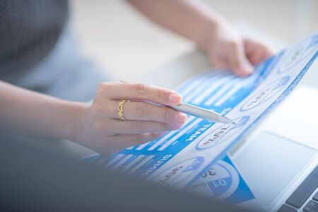 Asian business woman reviewing data in financial charts and graphs. Accountingの写真素材