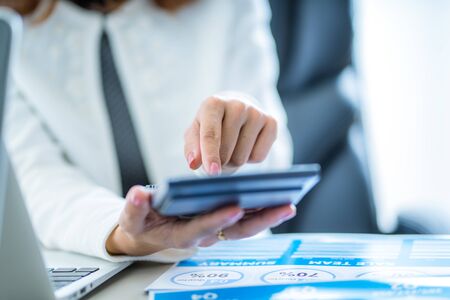 Asian business woman reviewing data in financial charts and graphs. Accountingの写真素材
