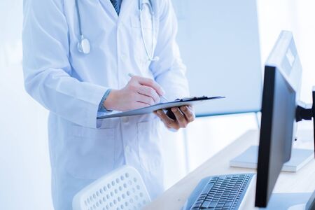 Close-up Of Male Doctor Filling The Medical Formの写真素材