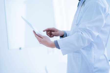 Close-up Of Male Doctor Filling The Medical Formの写真素材