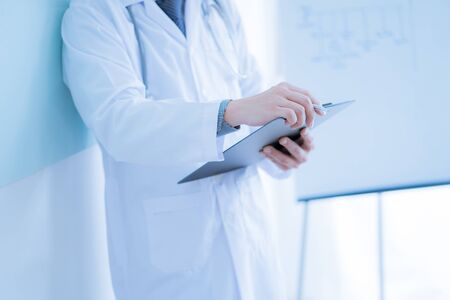 Close-up Of Male Doctor Filling The Medical Formの写真素材