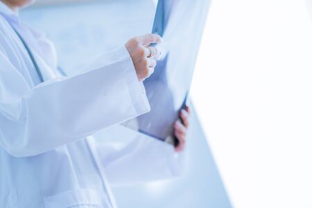 Asia Woman Doctor Looking at X-Ray Radiography in patient's Roomの写真素材
