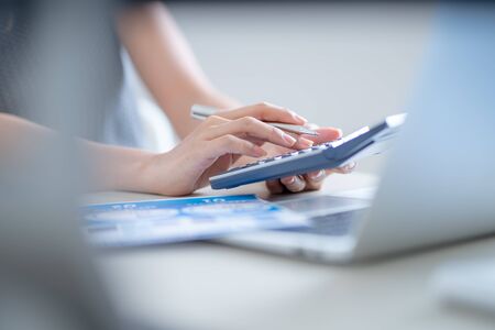 Asian business woman reviewing data in financial charts and graphs. Accountingの写真素材