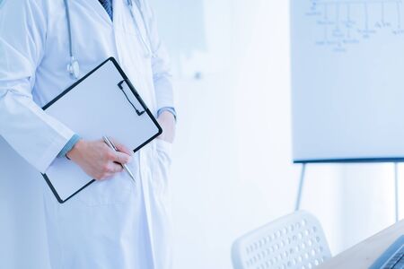 Close-up Of Male Doctor Filling The Medical Formの写真素材