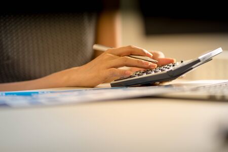 Asian business woman reviewing data in financial charts and graphs. Accountingの写真素材