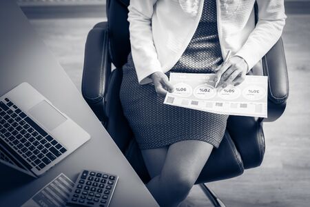 Asian business woman reviewing data in financial charts and graphs. Accountingの写真素材