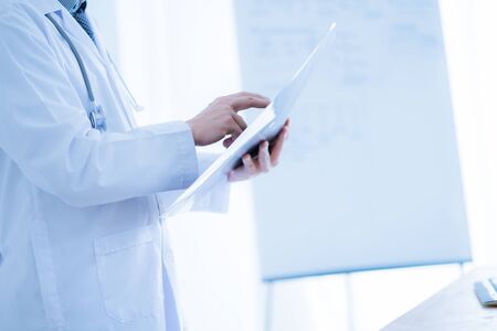 Close-up Of Male Doctor Filling The Medical Formの写真素材