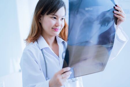 Asia Woman Doctor Looking at X-Ray Radiography in patient's Roomの写真素材