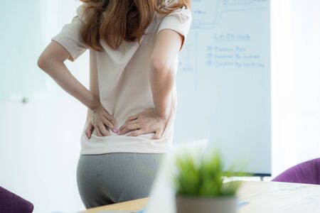Asian woman with back pain in officeの写真素材