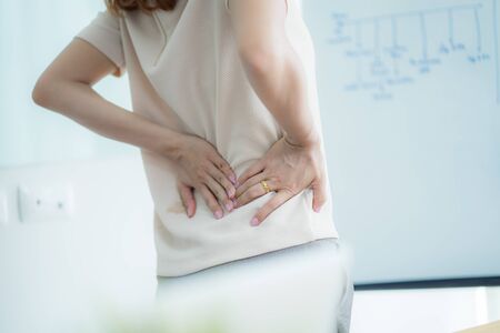 Asian woman with back pain in officeの写真素材