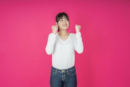 I won. Winning success happy woman celebrating being a winner. Dynamic image of caucasian female model on pink studio background. Victory, delight concept. Human facial emotions concept. Trendy colorsの写真素材