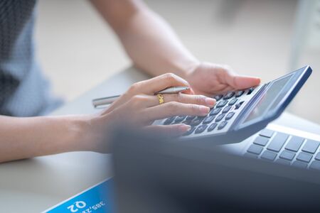 Asian business woman reviewing data in financial charts and graphs. Accounting