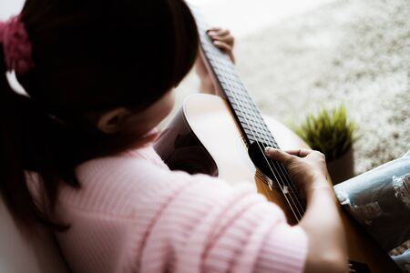 A beautiful asian woman playing acoustic guitarの写真素材