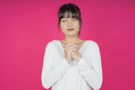 asian young casual style woman portrait isolated over pink background.の写真素材