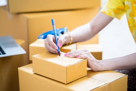 Young startup small business entrepreneur woman working with smart phone at home, Online business and delivery conceptの写真素材