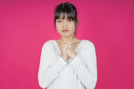 asian young casual style woman portrait isolated over pink background.の写真素材