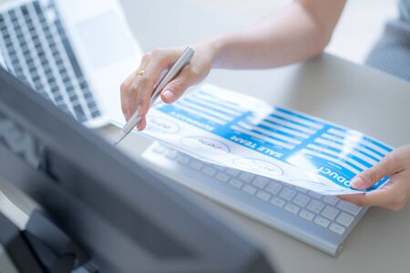 Asian business woman reviewing data in financial charts and graphs. Accountingの写真素材