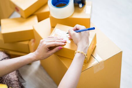 Young startup small business entrepreneur woman working with smart phone at home, Online business and delivery conceptの写真素材