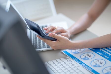 Asian business woman reviewing data in financial charts and graphs. Accountingの写真素材