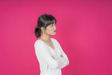 asian young casual style woman portrait isolated over pink background.の写真素材