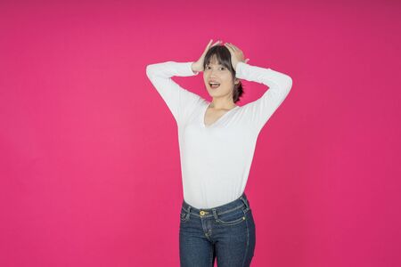 asian young casual style woman portrait isolated over pink background.の写真素材