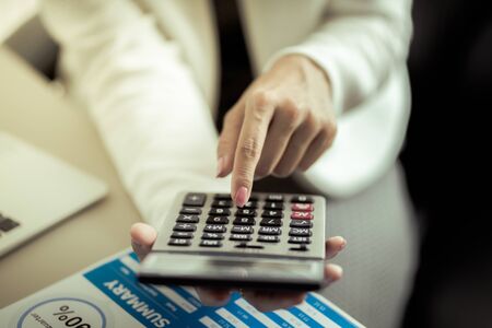 Asian business woman reviewing data in financial charts and graphs. Accountingの写真素材