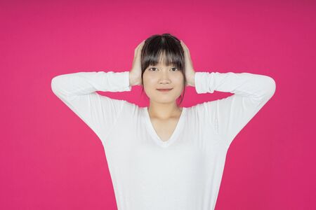 asian young casual style woman portrait isolated over pink background.の写真素材