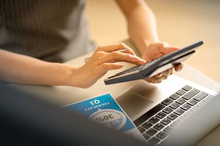 Asian business woman reviewing data in financial charts and graphs. Accountingの写真素材
