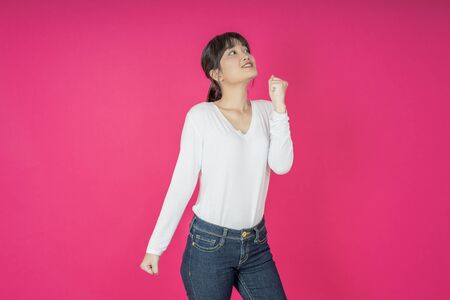 I won. Winning success happy woman celebrating being a winner. Dynamic image of caucasian female model on pink studio background. Victory, delight concept. Human facial emotions concept. Trendy colorsの写真素材