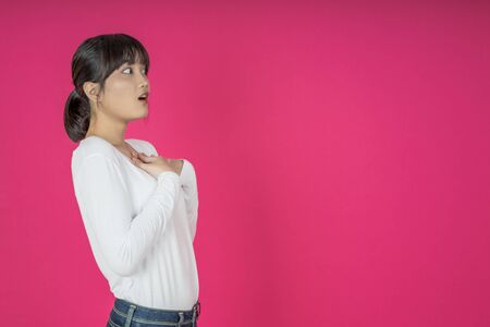 asian woman keeps hands on chest near heart, shows her kindness or favour, expresses sincere emotions, being kind hearted and honest. Body language and real feelings conceptの写真素材