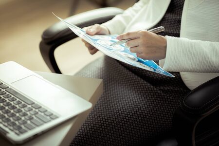 Asian business woman reviewing data in financial charts and graphs. Accountingの写真素材