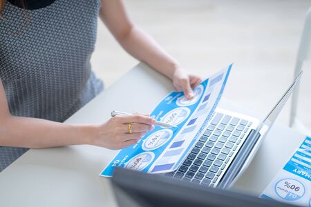 Asian business woman reviewing data in financial charts and graphs. Accountingの写真素材