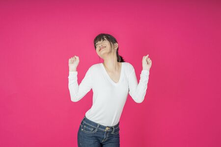 I won. Winning success happy woman celebrating being a winner. Dynamic image of caucasian female model on pink studio background. Victory, delight concept. Human facial emotions concept. Trendy colorsの写真素材