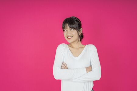 asian young casual style woman portrait isolated over pink background.の写真素材